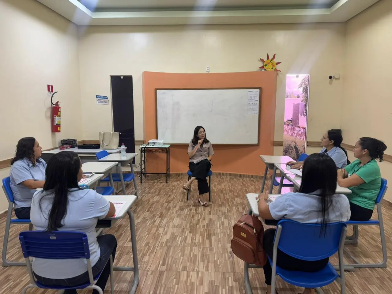 Foto da Doutora Paula lecionando em uma sala para professores